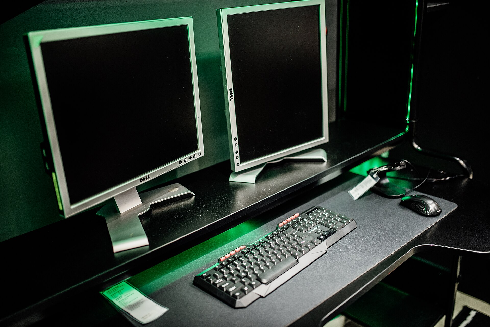 A two-monitor desk with a keyboard and mouse in the foreground